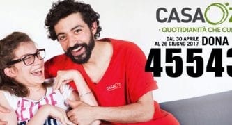 CasaOz - educatore abbraccia bambina sorridente, in posa per la campagna sms 2017