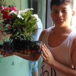 CasaOz - bambino mostra fiero una fioriera realizzata al laboratorio di giardinaggio