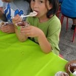 CasaOz - bambina affamata fa merenda con il dolce preparato al laboratorio di cucina
