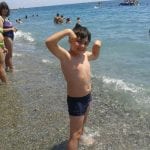 CasaOz - uno dei bambini che sorride felice in spiaggia