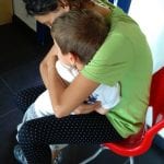 CasaOz - un'educatrice abbraccia teneramente un bambino