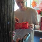 CasaOz - ragazzo che realizza una fioriera ricavata da una bottiglia di plastica durante il laboratorio creativo